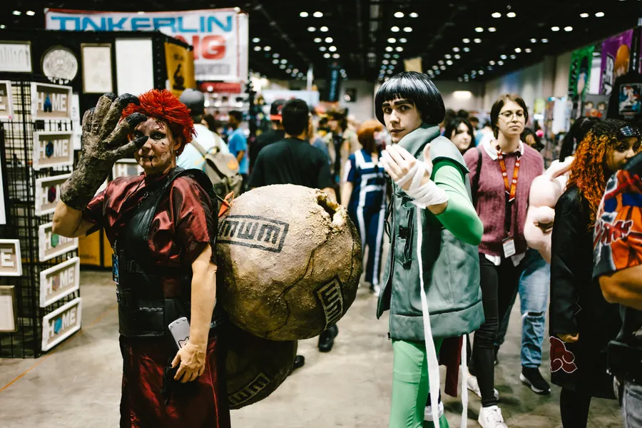 A busy convention hall full of people in costume.