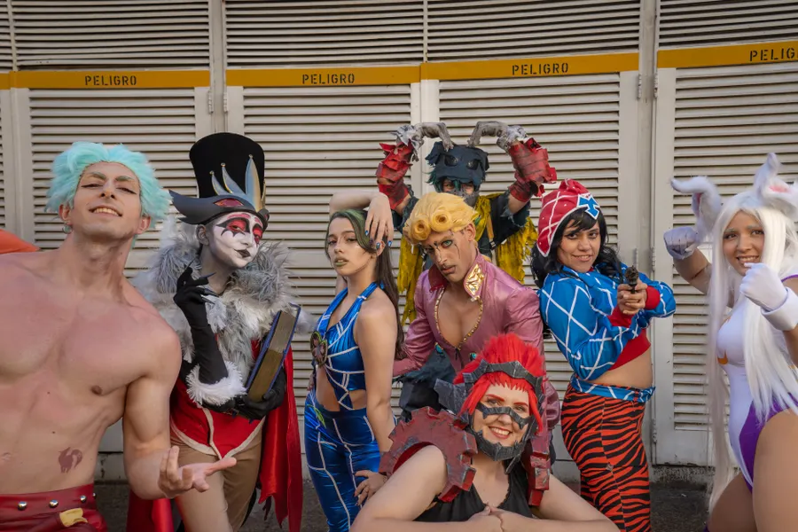 A group of cosplayers in bright costumes posing and laughing together.