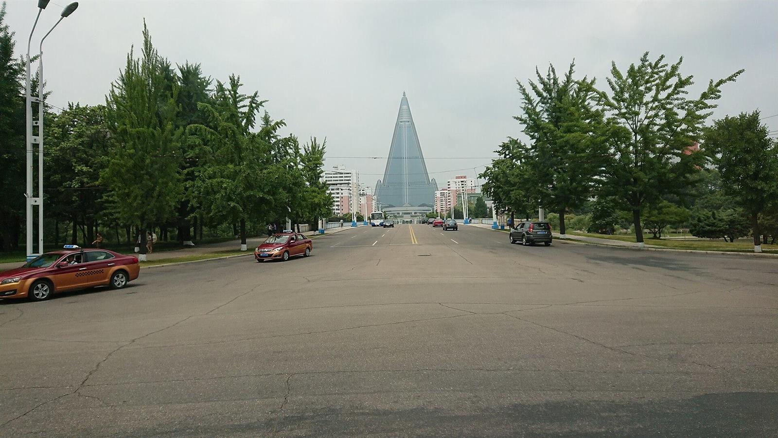 A broad empty avenue leading to the glass pyramid of the Ryugyong Hotel.